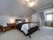 Cozy bedroom featuring a wrought iron bed frame and a cushioned reading chair at 1509 Churchill Downs Dr, Waxhaw, NC 28173