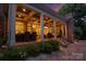 Inviting covered patio with outdoor seating, ceiling fans, brick fireplace, and a tranquil garden view at 1509 Churchill Downs Dr, Waxhaw, NC 28173