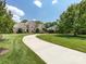Beautifully landscaped lawn leads to this impressive brick home with mature trees and a long driveway at 1509 Churchill Downs Dr, Waxhaw, NC 28173