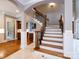 Elegant foyer featuring a staircase with iron railings, tile floors, and views into the kitchen and entryway at 1509 Churchill Downs Dr, Waxhaw, NC 28173