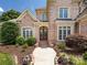 Inviting entryway with a charming brick facade, manicured landscaping, and a grand wooden door at 1509 Churchill Downs Dr, Waxhaw, NC 28173