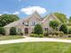 Stunning brick home boasts lush landscaping and a circular driveway, perfect for curb appeal at 1509 Churchill Downs Dr, Waxhaw, NC 28173