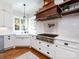 Close up view of a well equipped kitchen with stainless steel appliances and a custom wood range hood at 1509 Churchill Downs Dr, Waxhaw, NC 28173