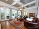 Elegant living room featuring hardwood floors, coffered ceilings and large windows offering plenty of natural light at 1509 Churchill Downs Dr, Waxhaw, NC 28173