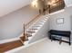Staircase with carpet and wood floors, featuring a white wood banister and railing at 1509 Churchill Downs Dr, Waxhaw, NC 28173