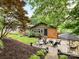 Charming home features a lovely backyard with a patio, lush landscaping, and mature trees at 1638 Wensley Dr, Charlotte, NC 28210