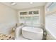 Modern bathroom with marble accents, freestanding tub, and lots of natural light at 1638 Wensley Dr, Charlotte, NC 28210