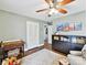 Neutral bedroom with a ceiling fan, warm wood floors and a small seating area at 1638 Wensley Dr, Charlotte, NC 28210