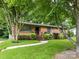 Charming brick home featuring a well-manicured lawn and lush landscaping at 1638 Wensley Dr, Charlotte, NC 28210