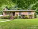 Charming brick home featuring a well-manicured lawn and lush landscaping at 1638 Wensley Dr, Charlotte, NC 28210
