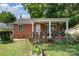 Charming brick home with a covered porch and small garden area at 2217 Tate St, Charlotte, NC 28216
