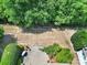 Aerial view of a lush backyard featuring a stone patio with furniture surrounded by beautiful landscaping and trees at 2224 Hartwell Ln, Fort Mill, SC 29707