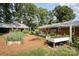 Spacious backyard with raised garden beds, an outbuilding and lush greenery at 2320 Doster Rd, Monroe, NC 28112