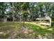 Expansive backyard with multiple outbuildings surrounded by mature trees at 2320 Doster Rd, Monroe, NC 28112