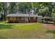 Charming brick home with a metal roof, lush lawn and large mature trees at 2320 Doster Rd, Monroe, NC 28112