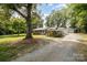 Ranch-style house with a carport and a detached garage, set back from the road with mature trees at 2320 Doster Rd, Monroe, NC 28112