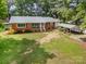 Charming brick home with a metal roof and a well-manicured lawn at 2320 Doster Rd, Monroe, NC 28112
