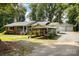 Charming brick home featuring a carport and detached garage, nestled amidst lush greenery and a spacious front yard at 2320 Doster Rd, Monroe, NC 28112