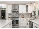 Modern kitchen featuring stainless steel appliances, white cabinets, and elegant stone backsplash at 2320 Doster Rd, Monroe, NC 28112