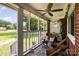 Inviting screened porch with a ceiling fan and comfortable seating with a view of the front yard at 2320 Doster Rd, Monroe, NC 28112