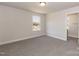 Bedroom featuring neutral carpet, base trim, large window, and en-suite bathroom access at 236 Mountain Island Rd # 40, Statesville, NC 28677