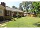 A spacious backyard with a well-maintained lawn, lush greenery, and mature trees at 2443 Knickerbocker Dr, Charlotte, NC 28212
