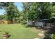 A sprawling backyard with a lush green lawn, mature trees, and a charming patio area at 2443 Knickerbocker Dr, Charlotte, NC 28212