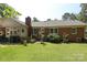 Large backyard featuring a well-manicured lawn, brick exterior, and mature landscaping at 2443 Knickerbocker Dr, Charlotte, NC 28212