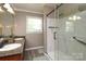 Bathroom featuring dual sinks, stylish granite countertops, and a modern walk-in shower at 2443 Knickerbocker Dr, Charlotte, NC 28212