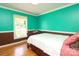 Bedroom with green walls, brown trim, and hardwood floors offering a calming, unique retreat at 2443 Knickerbocker Dr, Charlotte, NC 28212