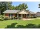 Well-manicured brick home featuring lush landscaping and a cozy front porch at 2443 Knickerbocker Dr, Charlotte, NC 28212