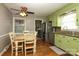 Eat-in kitchen featuring light green cabinets, hardwood floors, stainless appliances, and granite countertops at 2443 Knickerbocker Dr, Charlotte, NC 28212