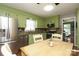 Eat-in kitchen featuring light green cabinets, hardwood floors, stainless appliances, and granite countertops at 2443 Knickerbocker Dr, Charlotte, NC 28212