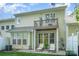 Backyard patio with seating beneath the upper-level balcony, lush green lawn, and neutral exterior at 2548 Chasewater Dr, Fort Mill, SC 29707
