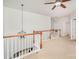 Bright hallway with chandelier, ceiling fan, neutral carpeting, and white railing at 2548 Chasewater Dr, Fort Mill, SC 29707