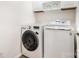 Convenient laundry room featuring a washer, dryer and storage shelves above at 2548 Chasewater Dr, Fort Mill, SC 29707