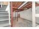 Unfinished basement space with concrete floor, exposed ceiling, and stairs at 300 Caldwell St, Kannapolis, NC 28083