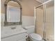 Bathroom with frosted glass shower, standard toilet, and sink with decorative mirror at 300 Caldwell St, Kannapolis, NC 28083