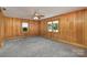 Spacious bedroom featuring wood paneling, soft carpet, and abundant natural light from two windows at 300 Caldwell St, Kannapolis, NC 28083