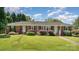 Charming one-story brick home with a lush green lawn and mature landscaping at 300 Caldwell St, Kannapolis, NC 28083