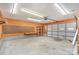 Spacious garage with plywood walls, concrete floor, fluorescent lights, and rolling garage door at 300 Caldwell St, Kannapolis, NC 28083