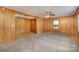 Cozy living room with wood paneled walls, plush carpet, and an open doorway at 300 Caldwell St, Kannapolis, NC 28083