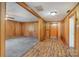 Cozy living room featuring wood paneling, plush carpet, and a seamless transition to a hardwood hallway at 300 Caldwell St, Kannapolis, NC 28083