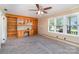 Living room featuring built-in shelving, windows, and ceiling fan at 300 Caldwell St, Kannapolis, NC 28083