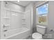 Bright bathroom featuring a shower-tub combo with sleek fixtures and a window at 3321 Treble Ct, Charlotte, NC 28262