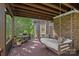 Spacious covered patio with a hanging bed, grill, and brick accents offers a perfect blend of relaxation and entertainment at 3506 Cardiff Ln, Matthews, NC 28104