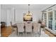 Formal dining room featuring a wooden table with tufted chairs, modern chandelier, and natural lighting at 3506 Cardiff Ln, Matthews, NC 28104