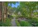 Charming fire pit area with lush greenery, benches, and a stone path offers a tranquil outdoor retreat at 3506 Cardiff Ln, Matthews, NC 28104