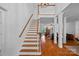 Bright foyer showcasing hardwood floors, staircase, open view to the living room and the beautiful stone fireplace at 3506 Cardiff Ln, Matthews, NC 28104