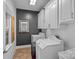 Functional laundry room with washer, dryer, storage cabinets, and a dark accent wall offers convenience and style at 3506 Cardiff Ln, Matthews, NC 28104